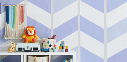 Design pintado na parede com fita ScotchBlue™ e acessórios para bebês e crianças na prateleira.
