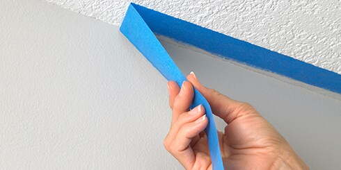 Remoção manual da Fita Scotch Blue™ da parede.