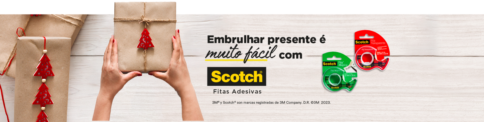 Mãos de mulher segurando um presente em uma mesa com Fita Mágica™ Scotch e Fita Transparente Scotch®