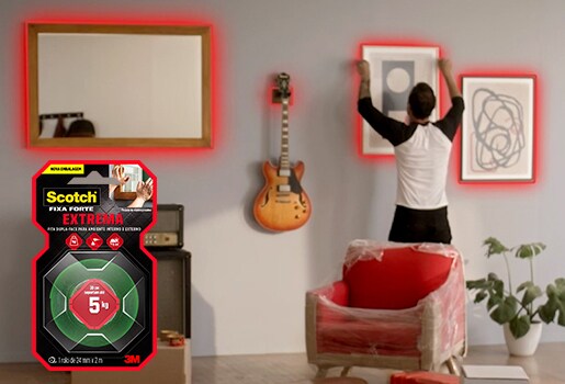 Homem pendurando objetos pesados na parede de sua sala de estar.
